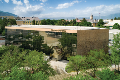 Aerial view with trees in front of the University Inn building during the summer.